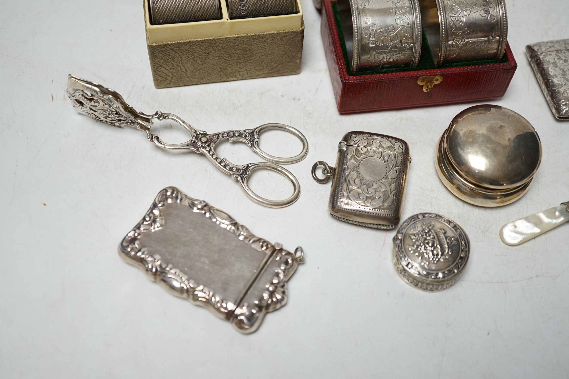 A cased pair of Edwardian engraved silver napkin rings, one other pair of engine turned silver napkin rings and sundry small items of silver, white metal and 925 including vesta cases, child's rattle, etc. Condition - po